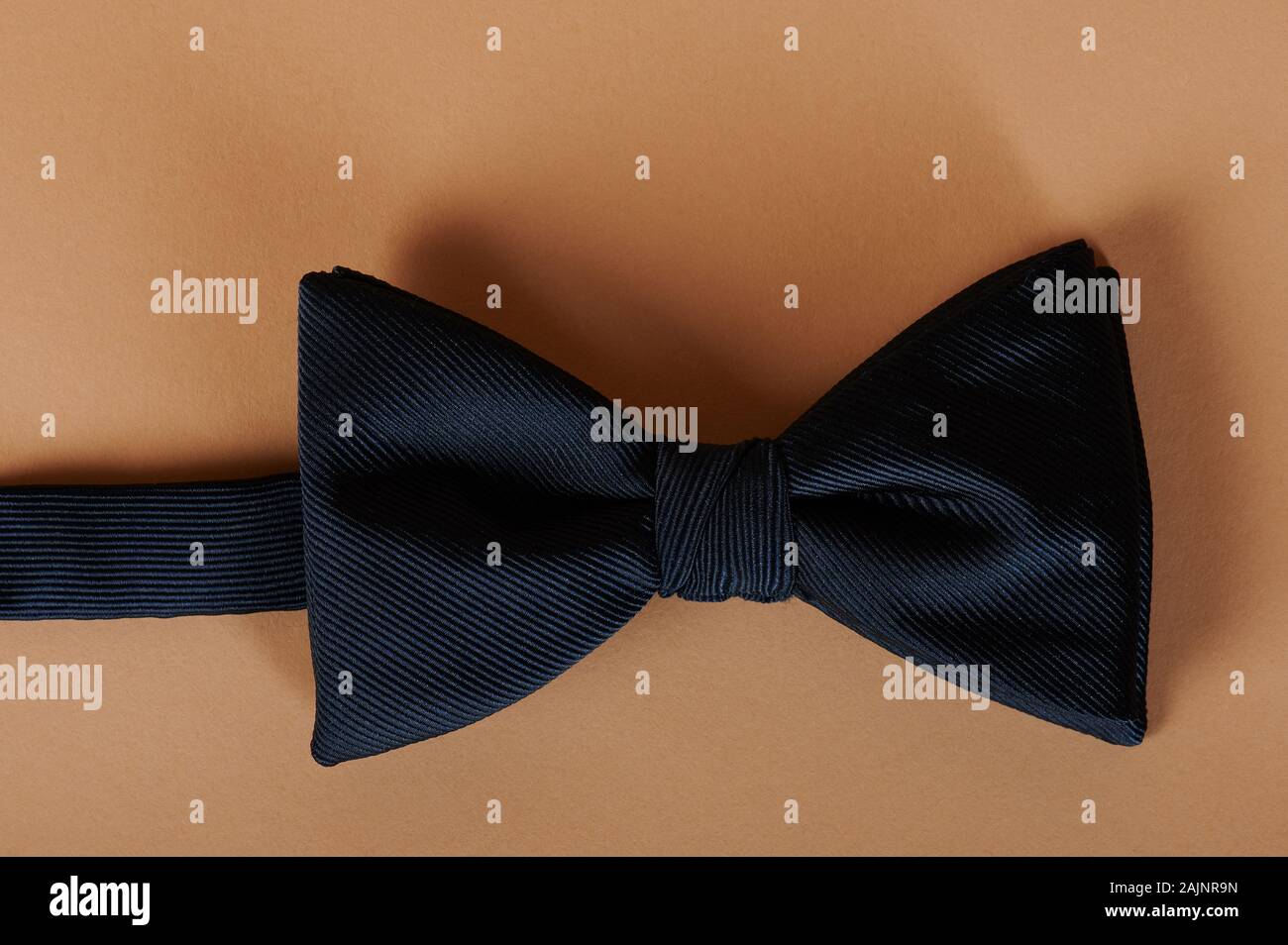 Mans blue bow tie on beige color background macro view Stock Photo