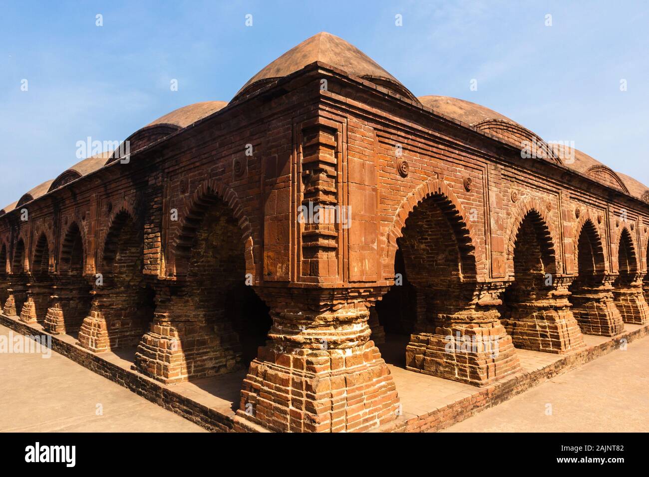 A symmetrical profile of the ornate, arched corridors of the ancient temple of Rasmancha built by the Malla Kings in Bishnupur in West Bengal in the 1 Stock Photo