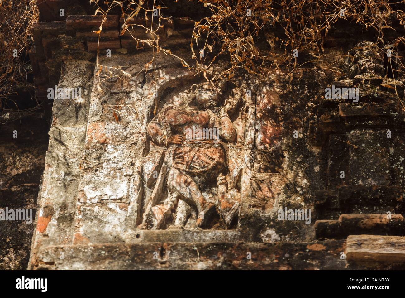 Bishnupur, West Bengal/India - February 6 2018: A carving of a dancing figurine inside an old, ruined, overgrown temple in the ancient archaeological Stock Photo