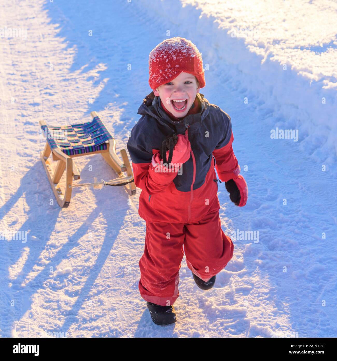Family with little children having fun in fresh snow in afternoon Stock