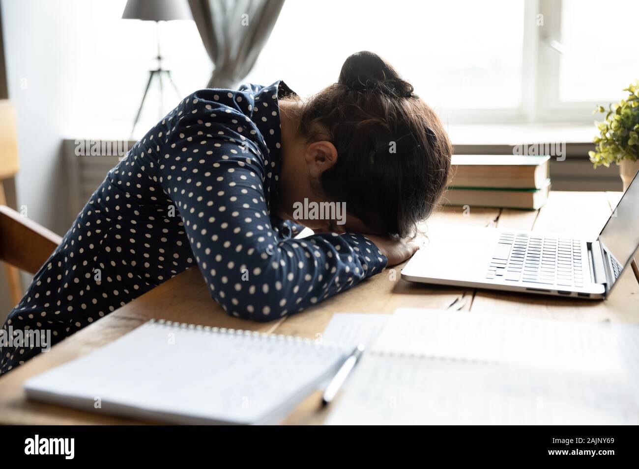 Tired indian girl student sleeping at desk exhausted after learning Stock Photo