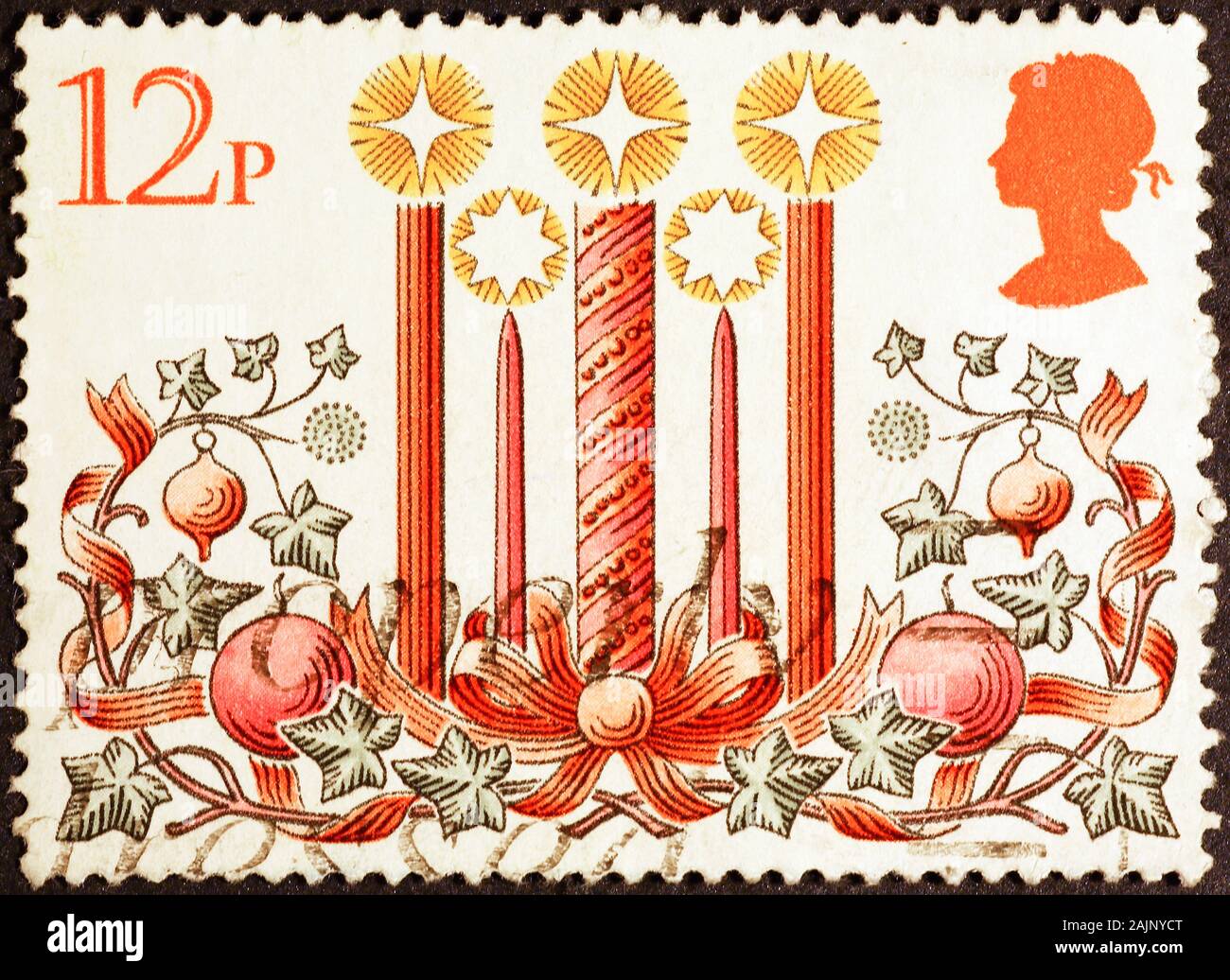 Candles and Christmas decorations on british postage stamp Stock Photo