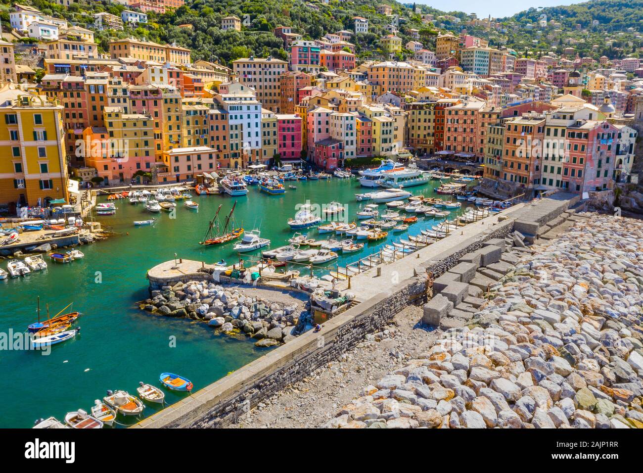 Aerial view of Camogli. Colorful buildings near the ligurian sea beach. View from above on boats and yachts moored in marina with green blue water. Stock Photo