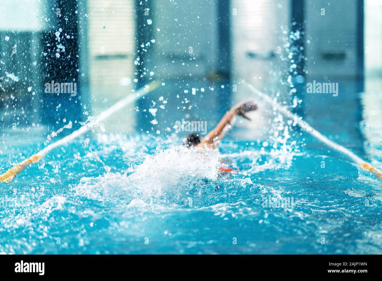 professional swimmer doing exercise in indoor swimming pool. Stock Photo