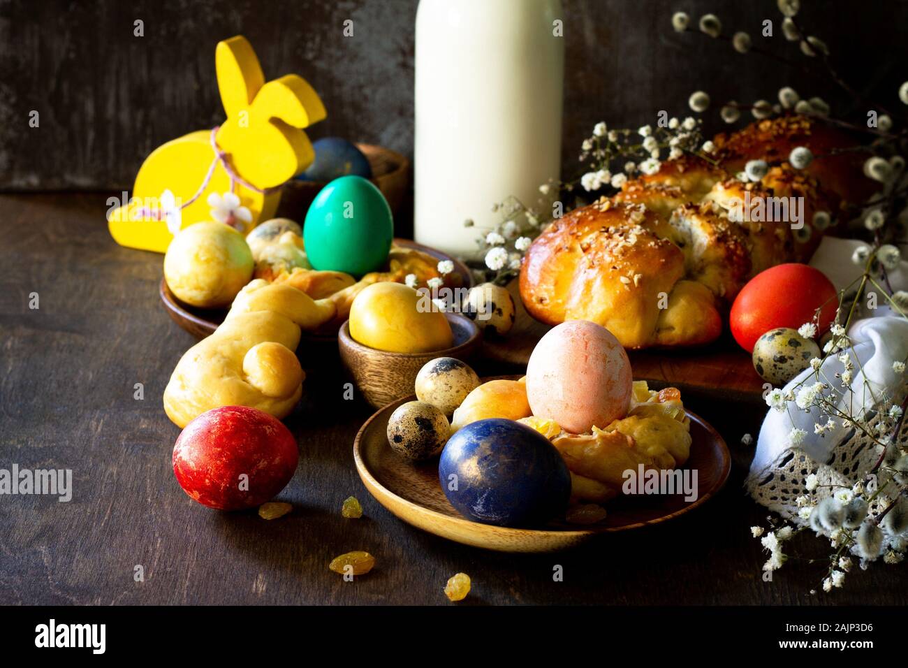 Easter holiday table. Easter cakes and colored eggs on a wooden table. Stock Photo