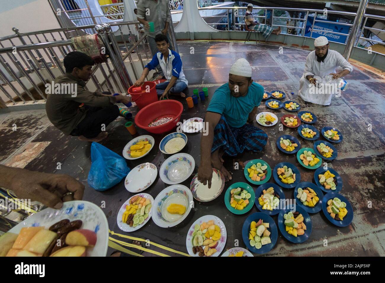 Bangladeshi Muslim devotees prepare Iftar on a vessel at Shadarghat Launch Terminal in Dhaka during the holy month of Ramadan. Bangladesh. Stock Photo