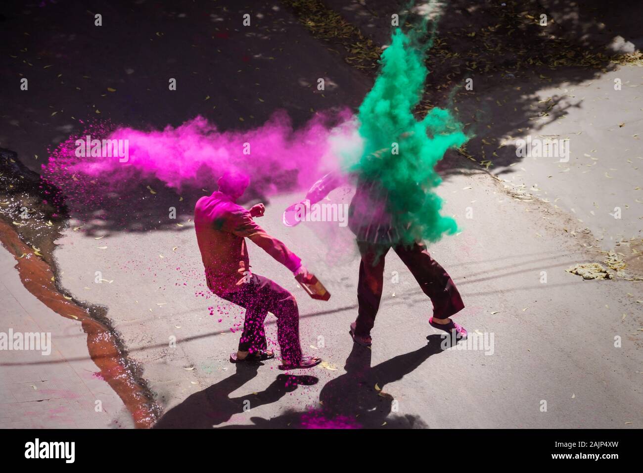 Two indian men throwing paint in colorful powder clouds for Holi, Jaipur, Rajasthan, India Stock Photo