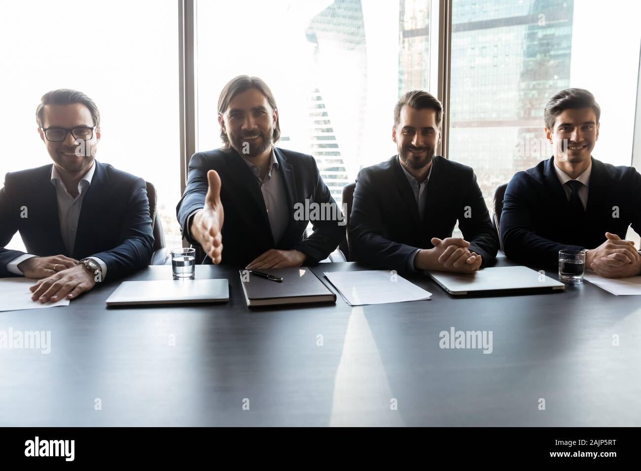 Smiling businessman stretch hand greeting with employee Stock Photo - Alamy