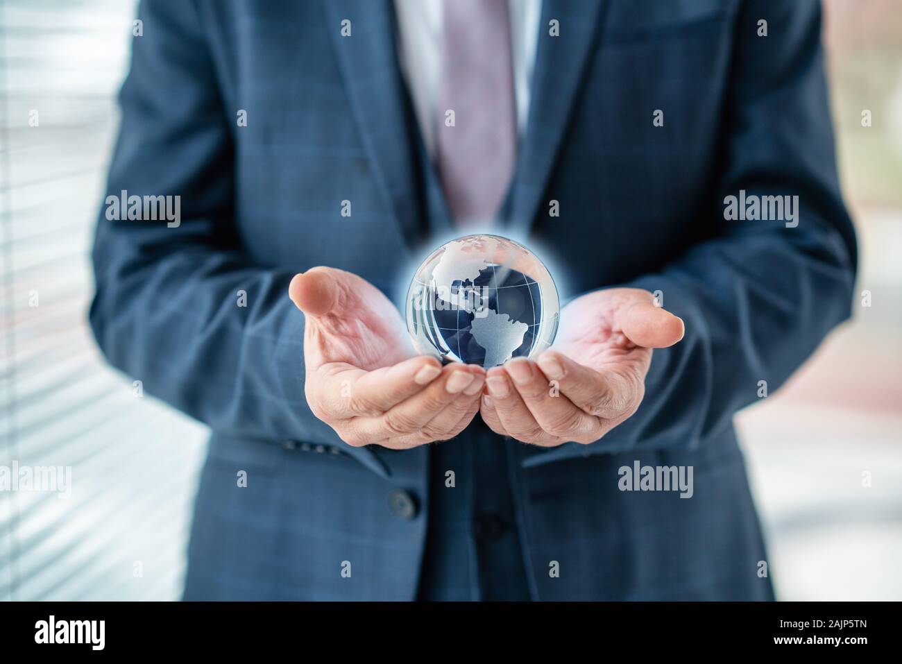 Businessman is holding world sphere. concept of beeing connected and ruling the world, global domination Stock Photo