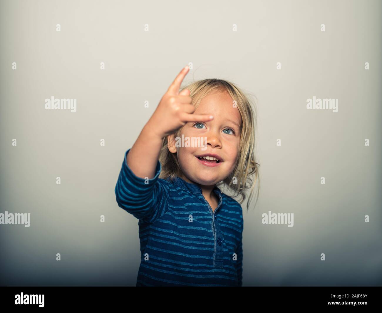 Studio portrait of toddler doing heavy metal sign with his fingers Stock Photo