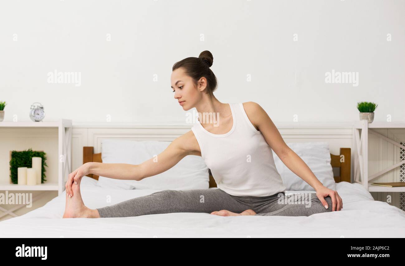 Morning routine concept. Girl stretching her legs and doing yoga in her
