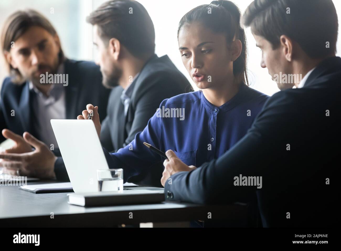 Multiethnic employees discuss business ideas collaborating at meeting Stock Photo