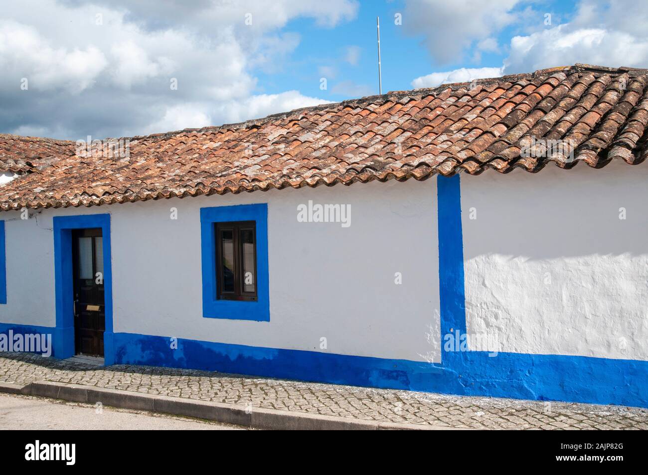 Quaint blue and white houses line a street in a small Parish in the municipality of Obidos, Portugal Stock Photo