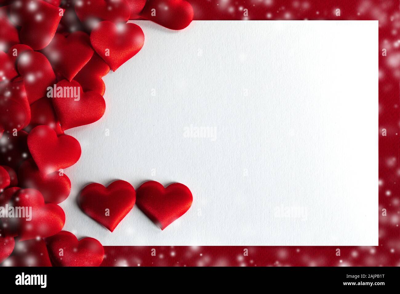 Valentine's day many red silk hearts background , border frame with white card with copy space, love concept Stock Photo