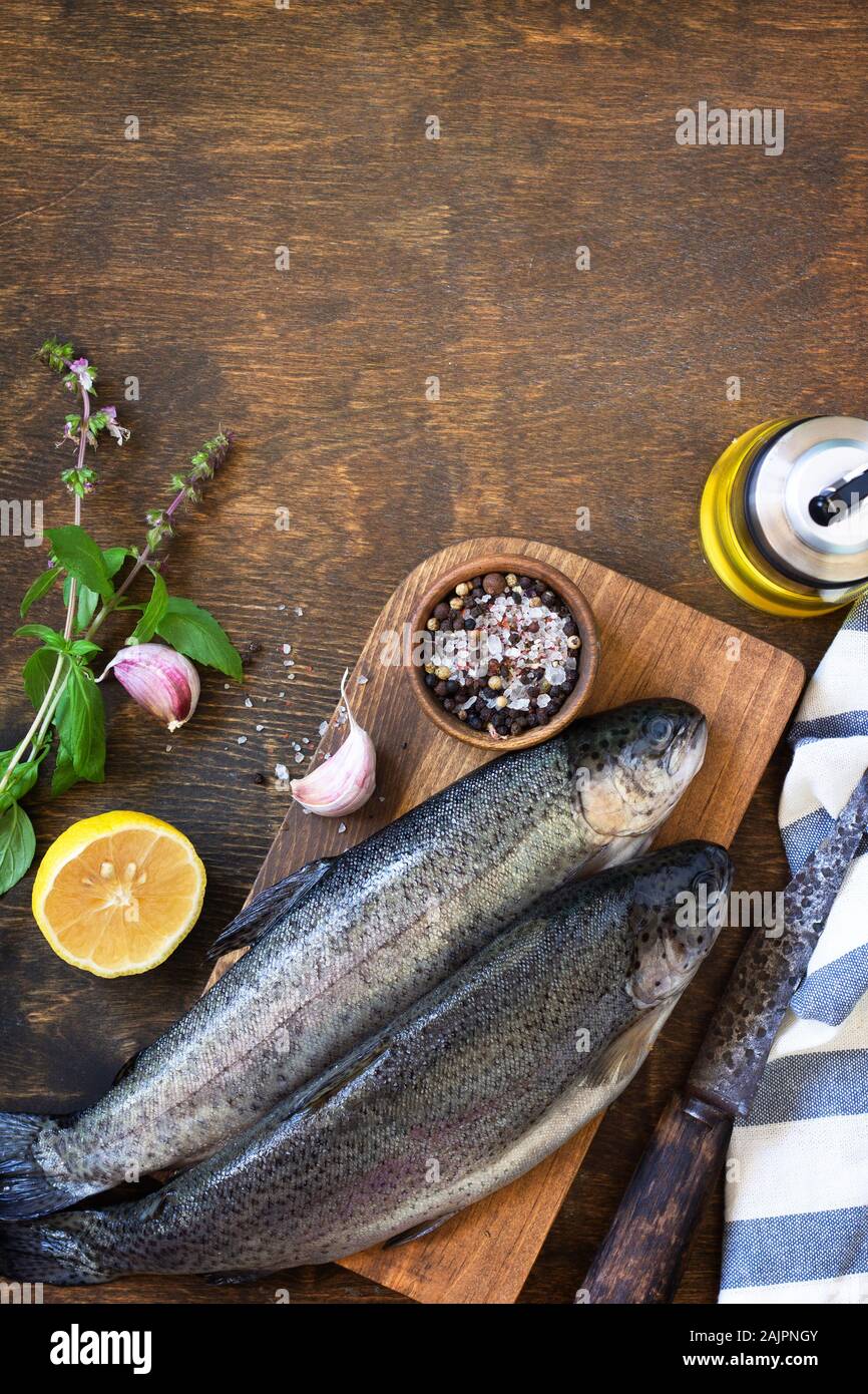 Fresh raw trout fish and pickle ingredients on a wooden table. Cooking