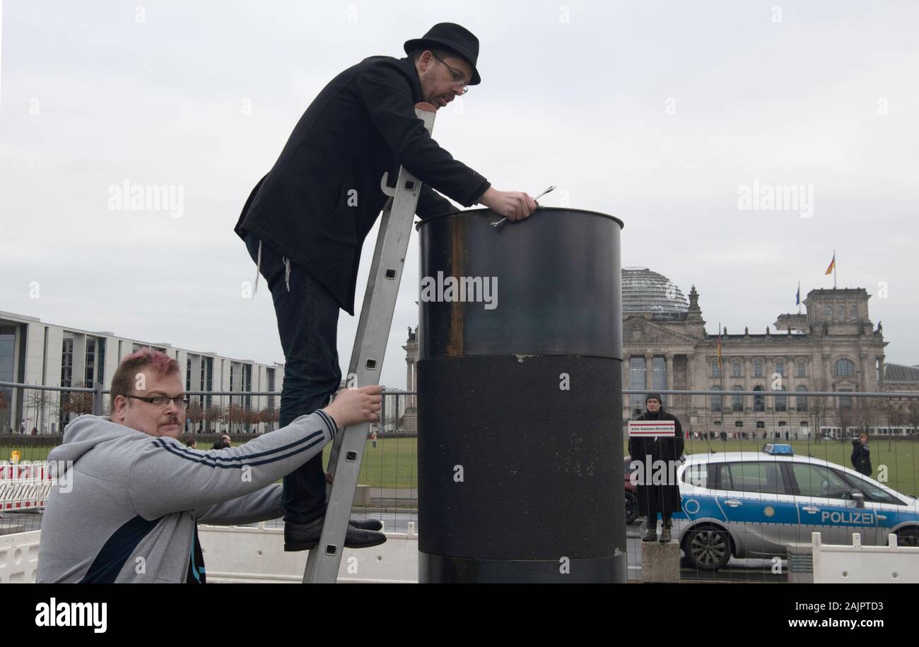 Berlin, Germany. 05th Jan, 2020. 05 January 2020, Berlin: The author Eliyah Havemann (above) reattaches a previously dismantled steel plate to the controversial steel column of the artists' collective 'Centre for Political Beauty' (ZPS) opposite the Reichstag building. Several activists have tried to dismantle the controversial steel column of the artists' collective 'Centre for Political Beauty' (ZPS) in Berlin. 'One should not make art and politics with ashes of victims of the Holocaust,' Havemann told the dpa on Sunday, explaining the reasons. The police stopped the action and ZPS filed a c Stock Photo
