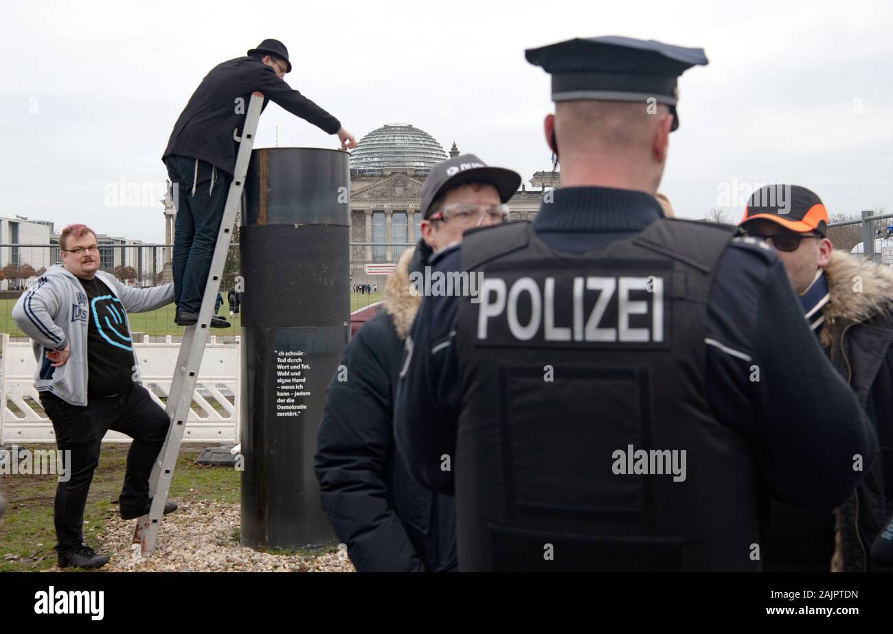 Berlin, Germany. 05th Jan, 2020. 05 January 2020, Berlin: Author Eliyah Havemann (2nd from left) reattaches a steel plate that was previously removed to the controversial steel column of the artists' collective 'Centre for Political Beauty' (ZPS) opposite the Reichstag building. Several activists have tried to dismantle the controversial steel column of the artists' collective 'Centre for Political Beauty' (ZPS) in Berlin. 'One should not make art and politics with ashes of victims of the Holocaust,' Havemann told the dpa on Sunday, explaining the reasons. The police stopped the action and ZPS Stock Photo