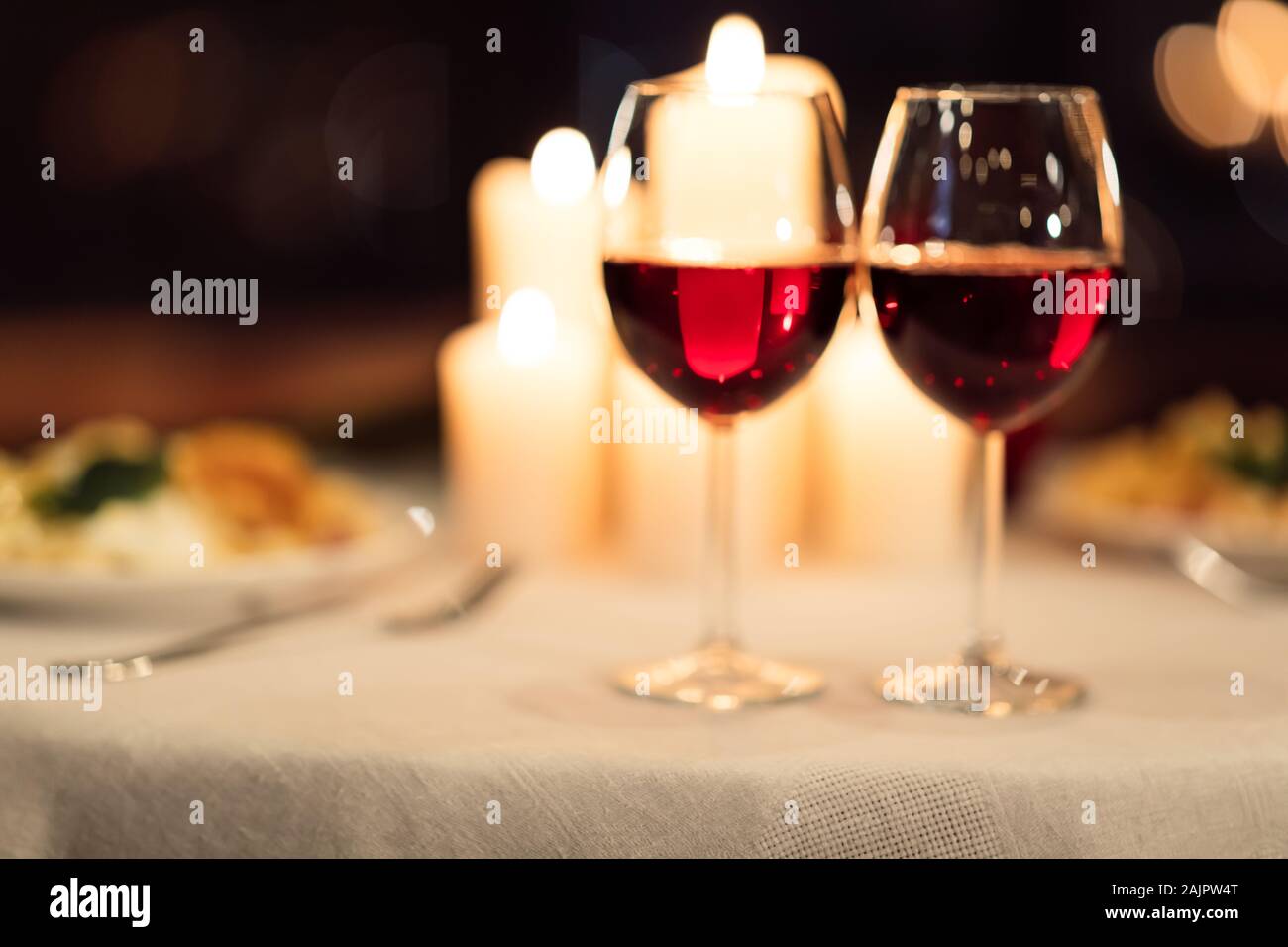 Two Glasses Of Red Wine Standing On Table With Candles In Restaurant.  Romantic Valentine's Day Date Background. Selective Focus Stock Photo -  Alamy