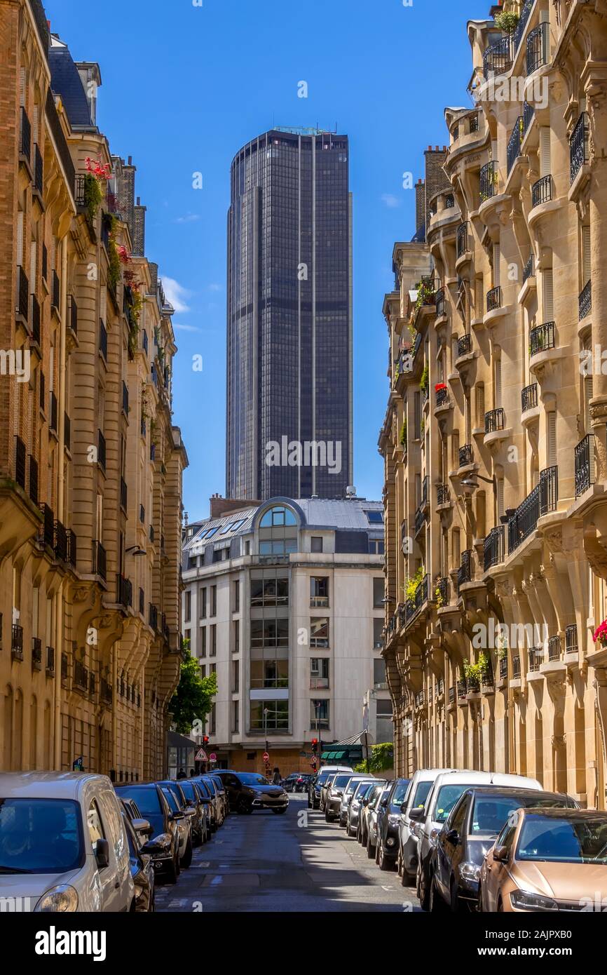 France. Paris. Montparnasse Tower at the end of a narrow street. Sunny summer day. Lots of parked cars Stock Photo