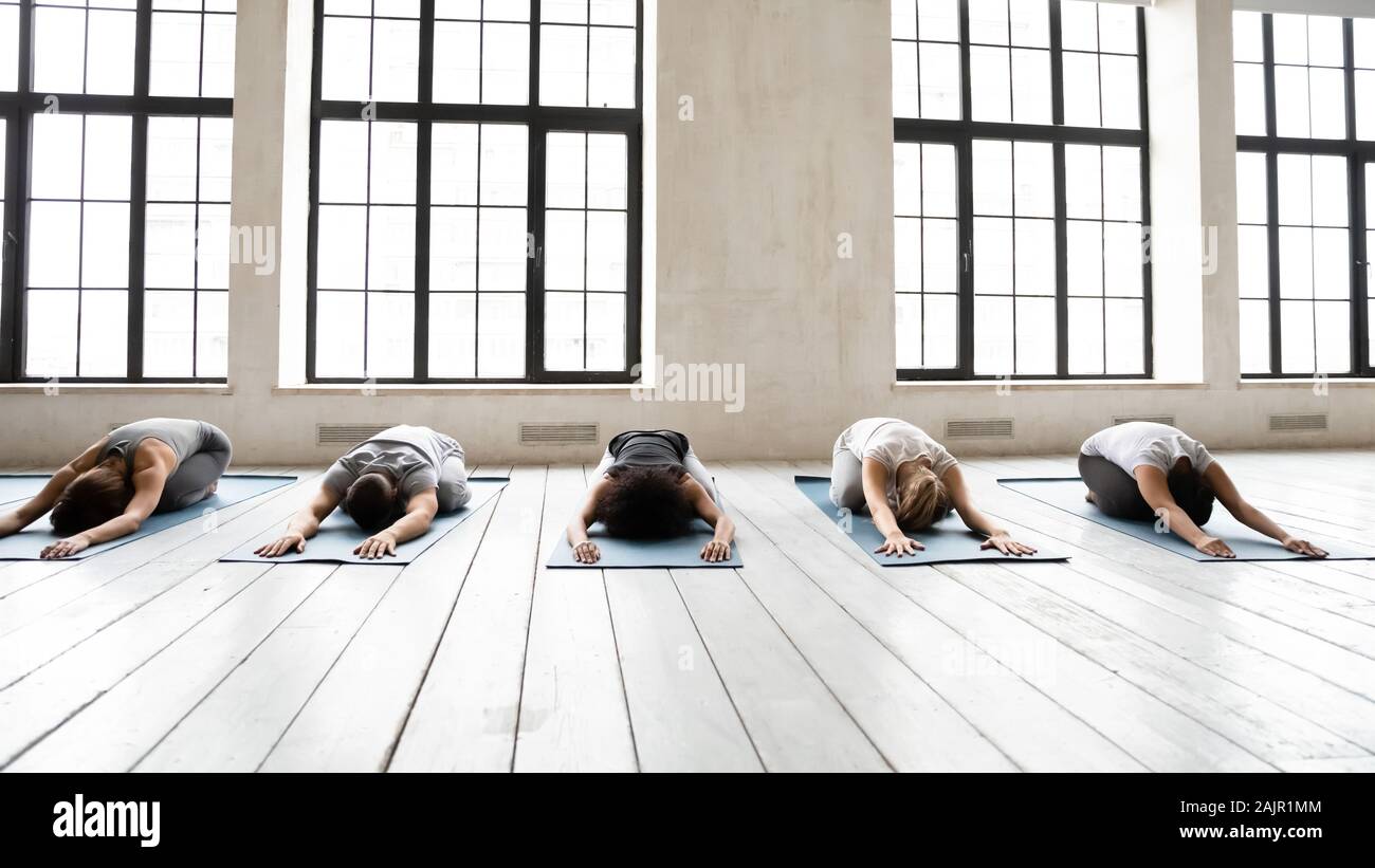 Diverse people stretching in Child pose at group yoga lesson Stock Photo
