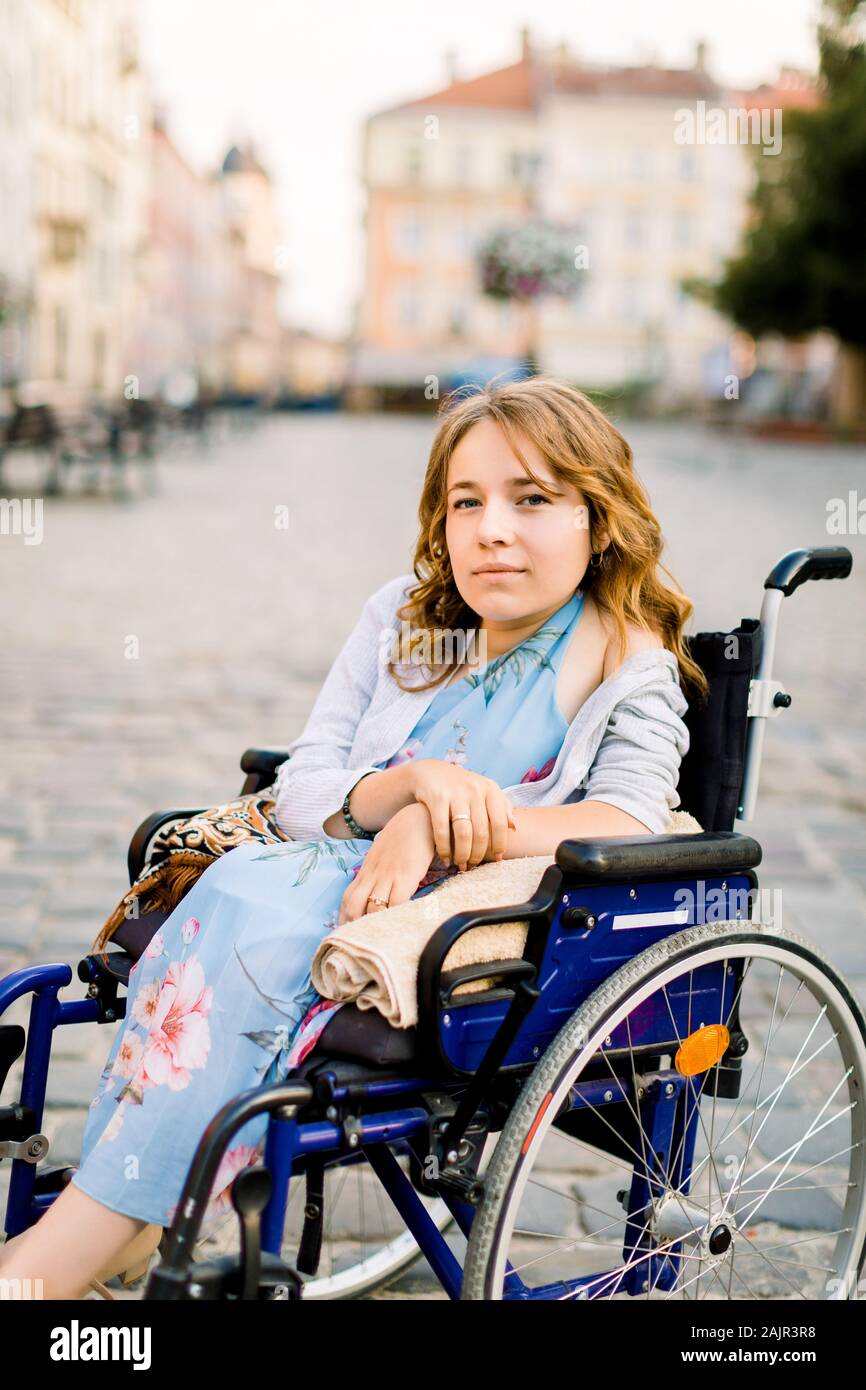 Closeup portrait of pretty young smiling disabled woman in wheelchair ...