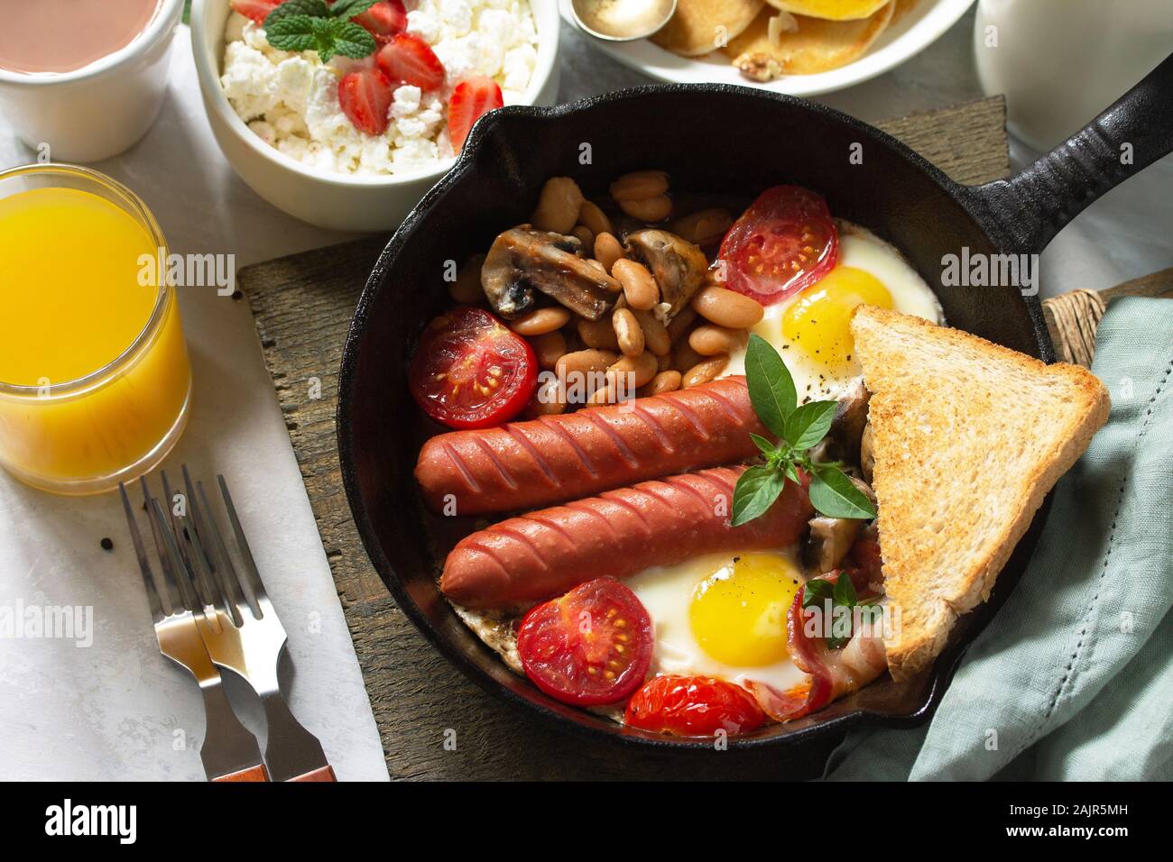 Keto breakfast fried eggs, sausages, beans, bacon, mushrooms, grilled