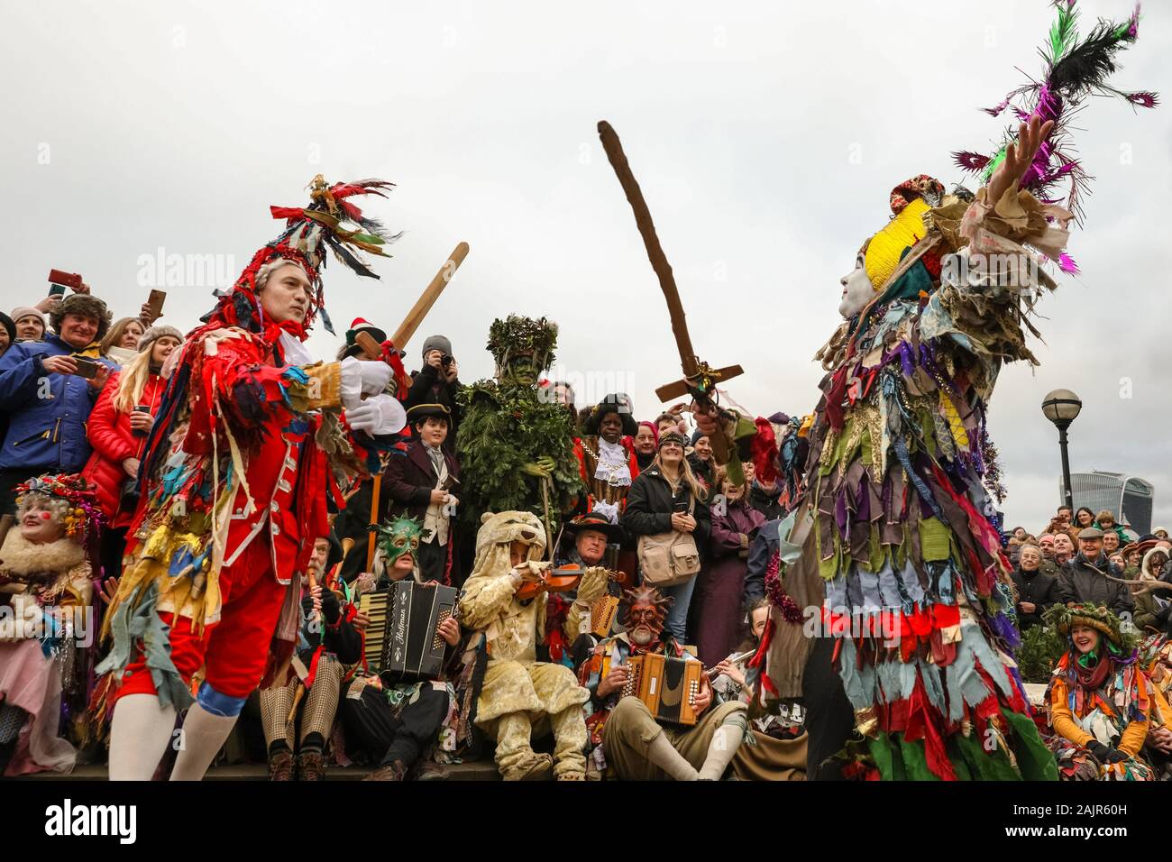 London, UK. 5th Jan 2020. The Mummers perform the traditional 'freestyle' St. George Folk Combat Play. The 25th annual Twelfth Night Celebration, an ancient Midwinter custom, is held at Bankside, performed by 'The Lions part' players. The Holly Man, decked in green foliage, is piped over the River Thames. He is joined by the London Mummers, to toast (wassail) the people, and perform freestyle folk combat play in colourful costumes. The procession moves across the river, to Shakespeare's Globe and on to the St George Inn, Southwark. Credit: Imageplotter/Alamy Live News Stock Photo