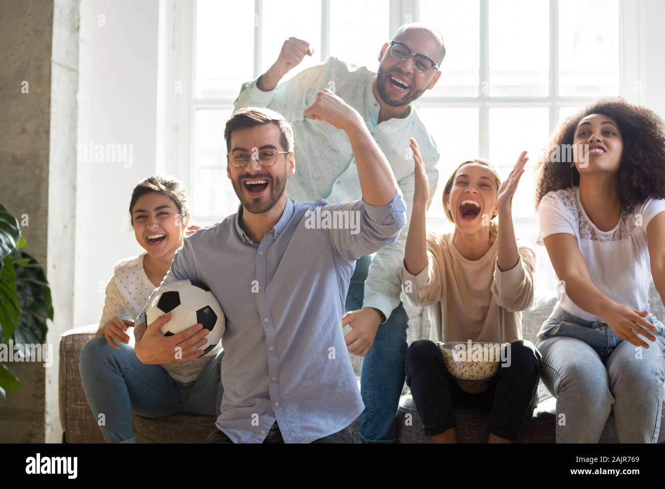 Excited multiracial young people cheering watching football Stock Photo ...