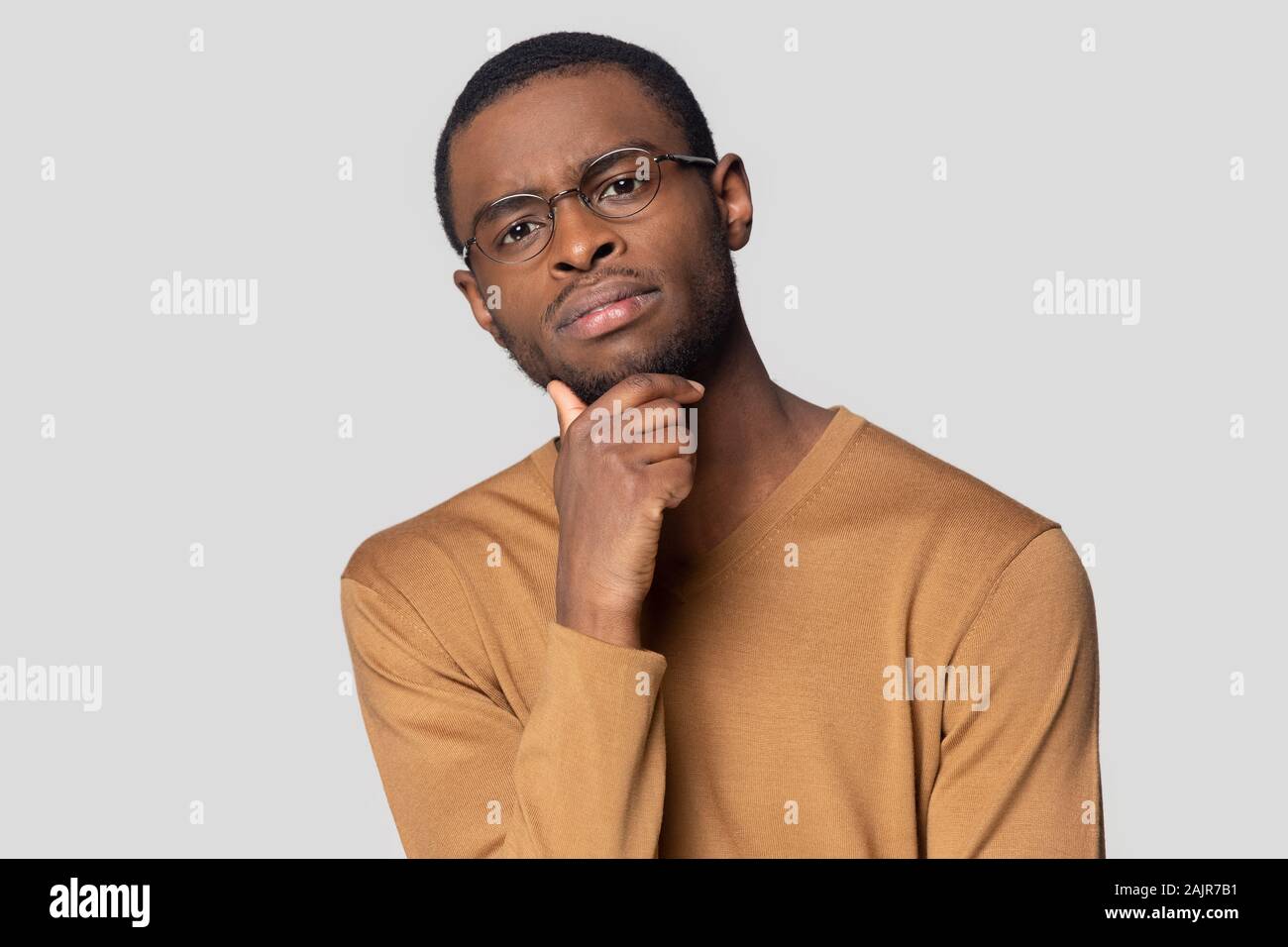 Concerned doubting african guy looking at camera studio shot Stock Photo