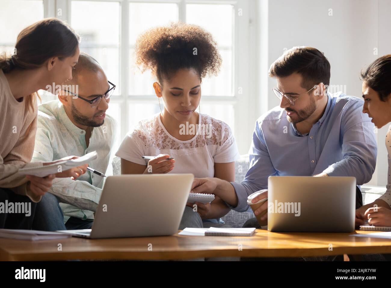 Multiethnic diverse students brainstorm preparing for exam together Stock Photo