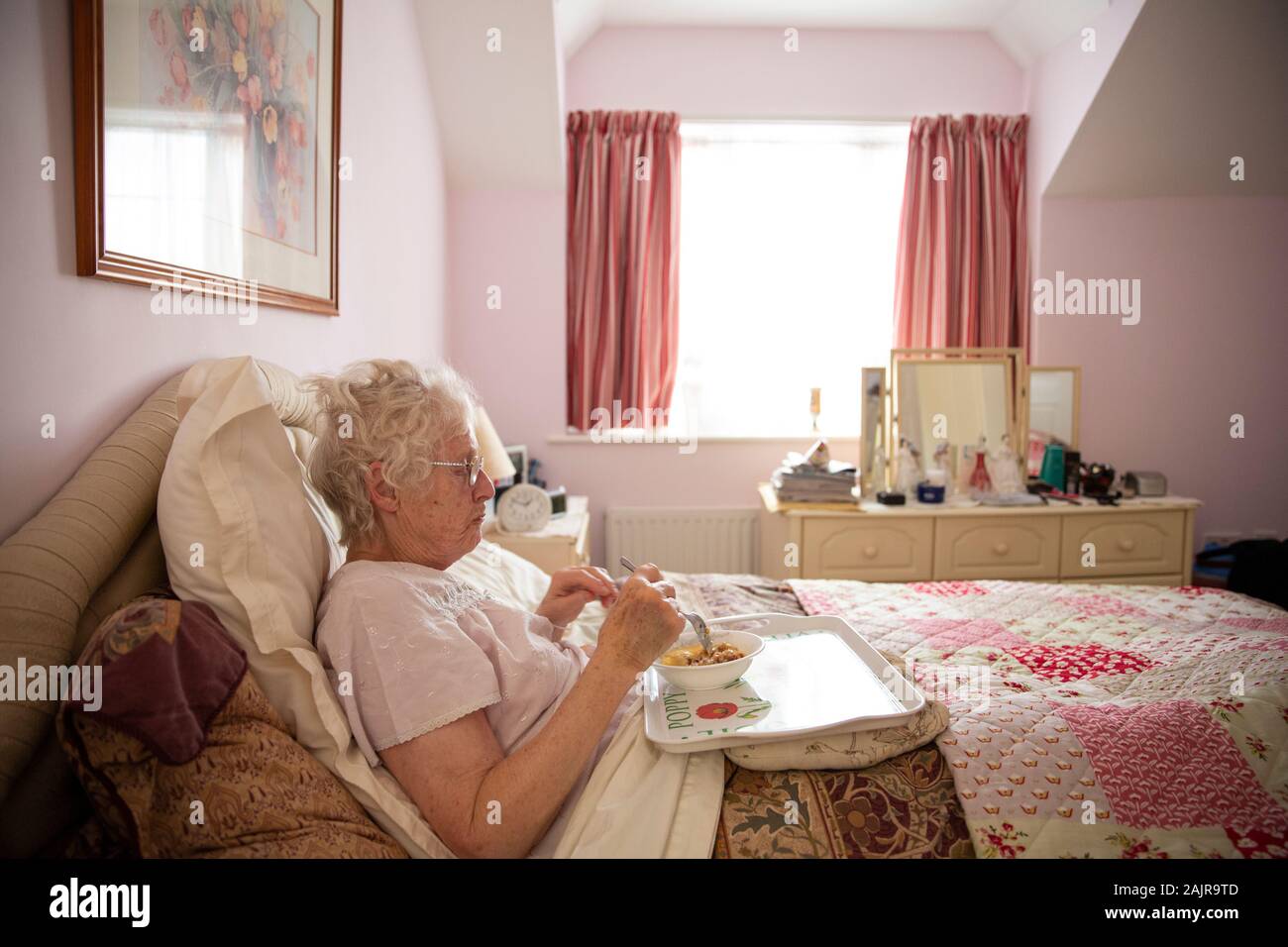 83 year old elderly woman, eating her lunch alone in bed, England, United Kingdom Stock Photo