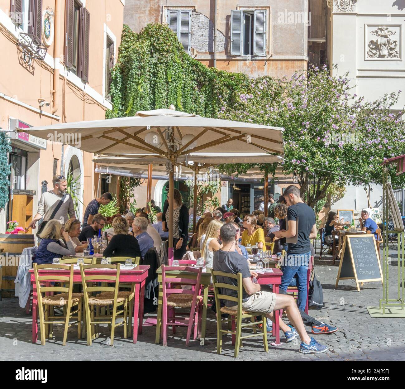 ROME, ITALY - OCTOBER 10, 2017: people are eating outdoors in a typical trattoria in Trastevere, historic district of Rome, Italy Stock Photo
