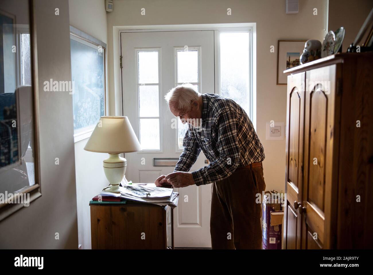 87 year old elderly man, living alone, stood in his hallway, England, United Kingdom Stock Photo
