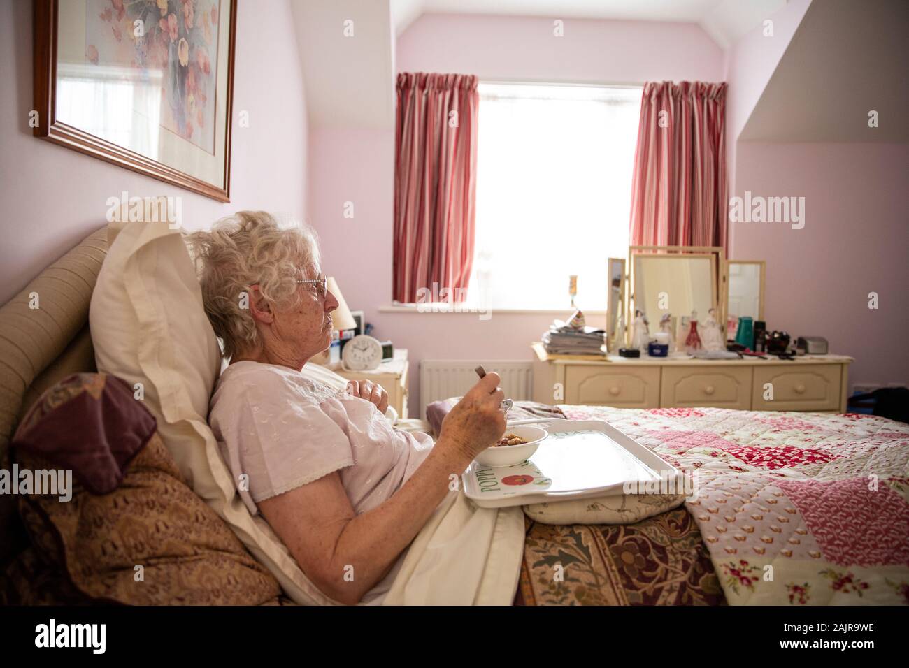 83 year old elderly woman, eating her lunch alone in bed, England, United Kingdom Stock Photo