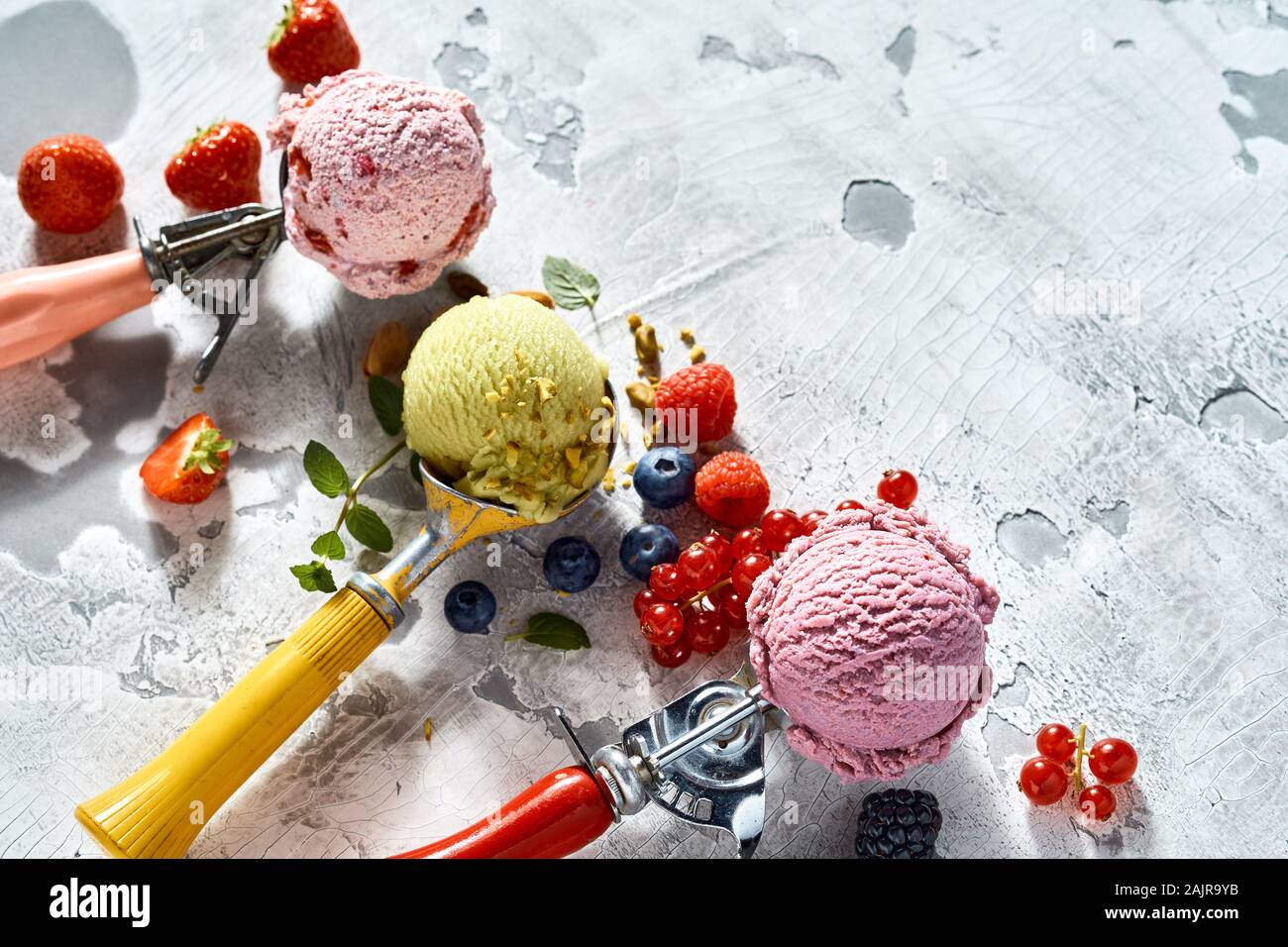 Three ice cream scoops with assorted flavors of mixed berry and