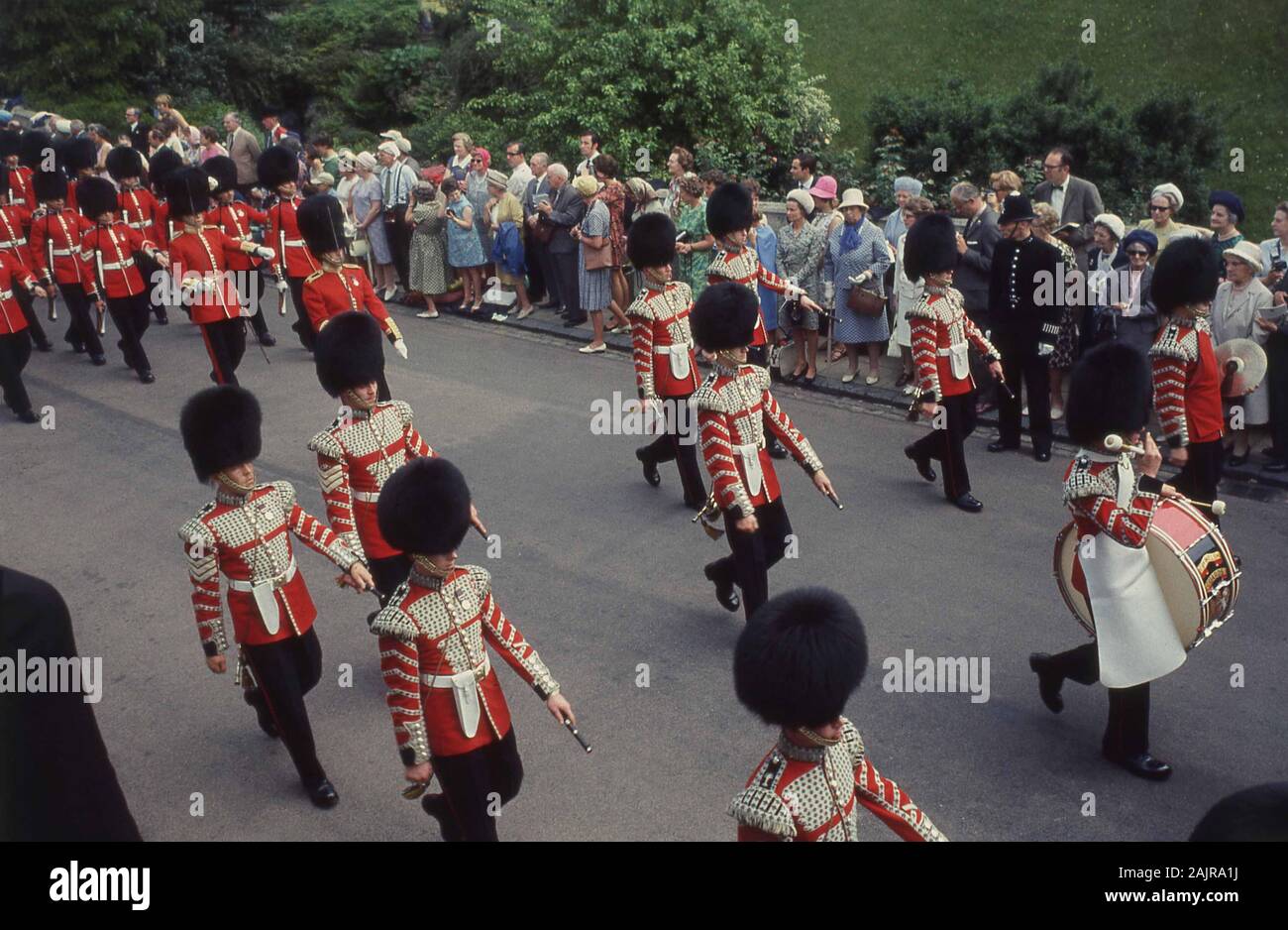 1960s, historical, spectators watching the Queen's Guard and marching band at the most Noble Order of the Garter, outside Windsor Castle, Windsor, England, UK. The most Noble Order of the Garter was founded by King Edward III of England in 1348 and is the most senior order of Knighthood in the British honours system. Stock Photo