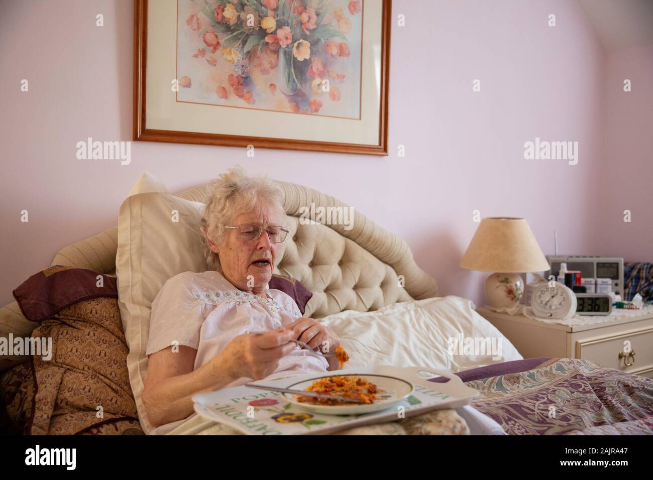 83 year old elderly woman, eating her lunch alone in bed, England