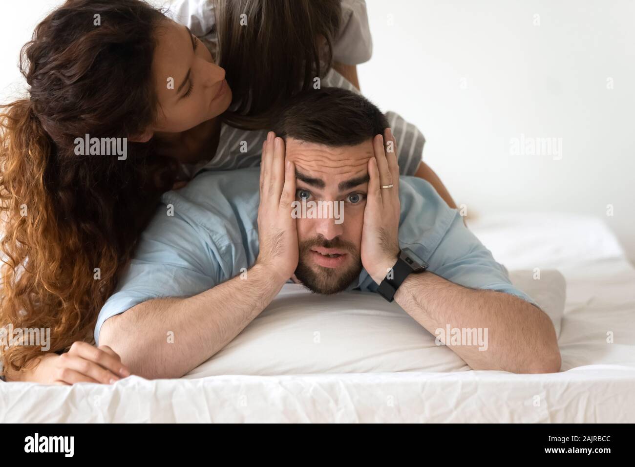 Face of stressed father is annoyed by noisy household people Stock Photo