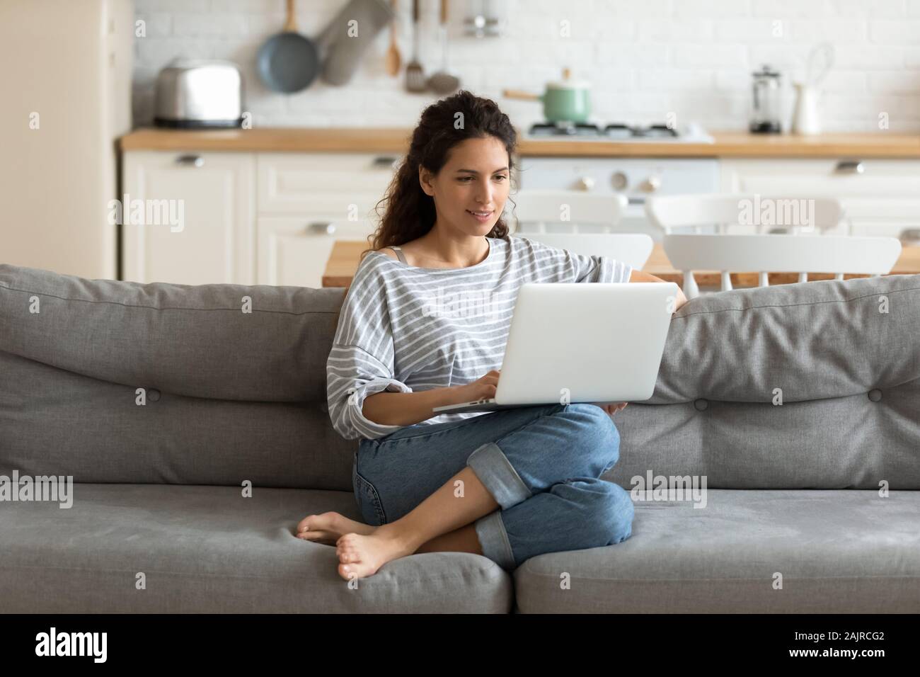 Female holding on lap notebook looking at screen writing email Stock Photo