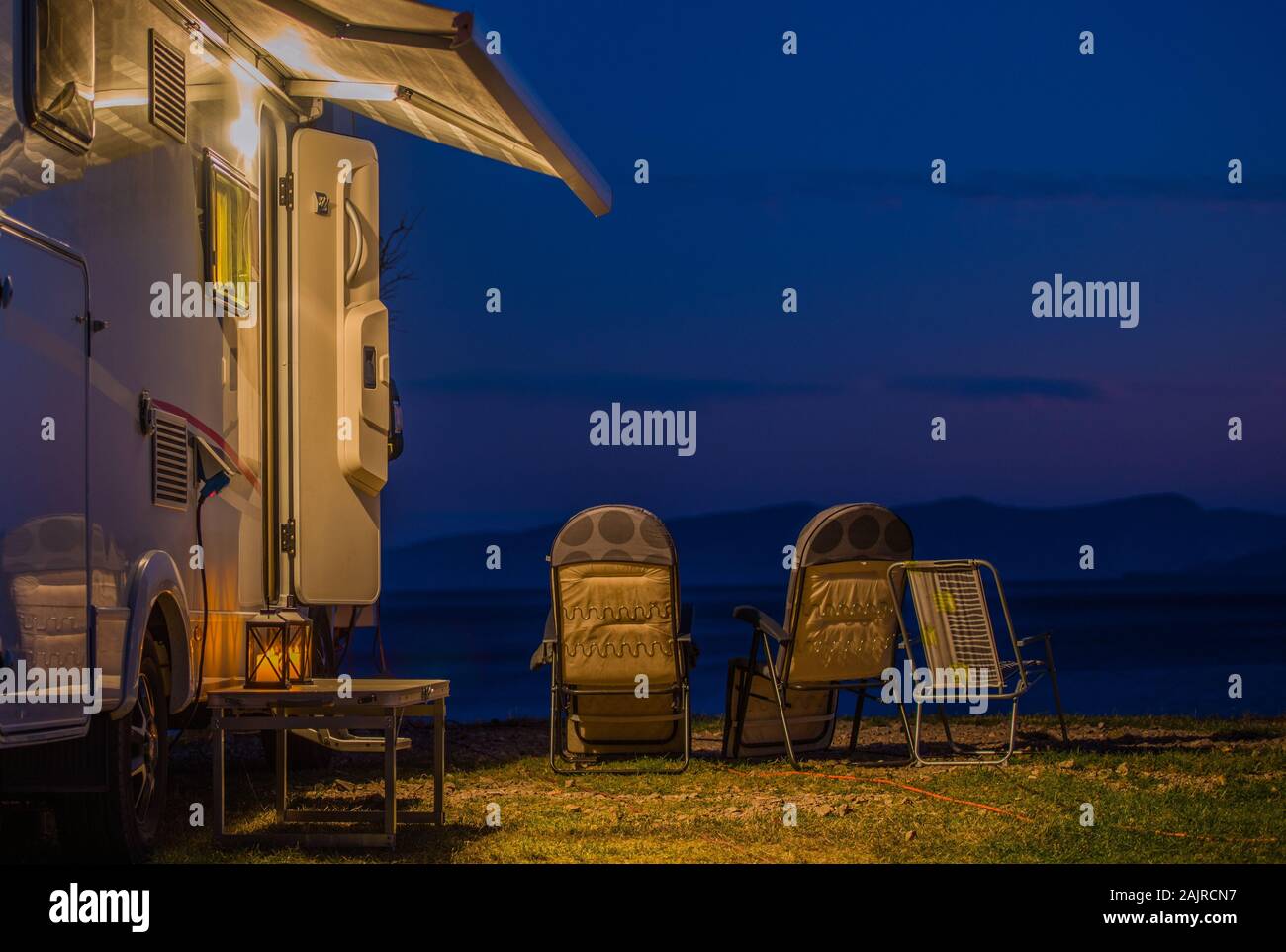 Late Evening in the RV Park. Modern Camper Van Motorhome and Camping