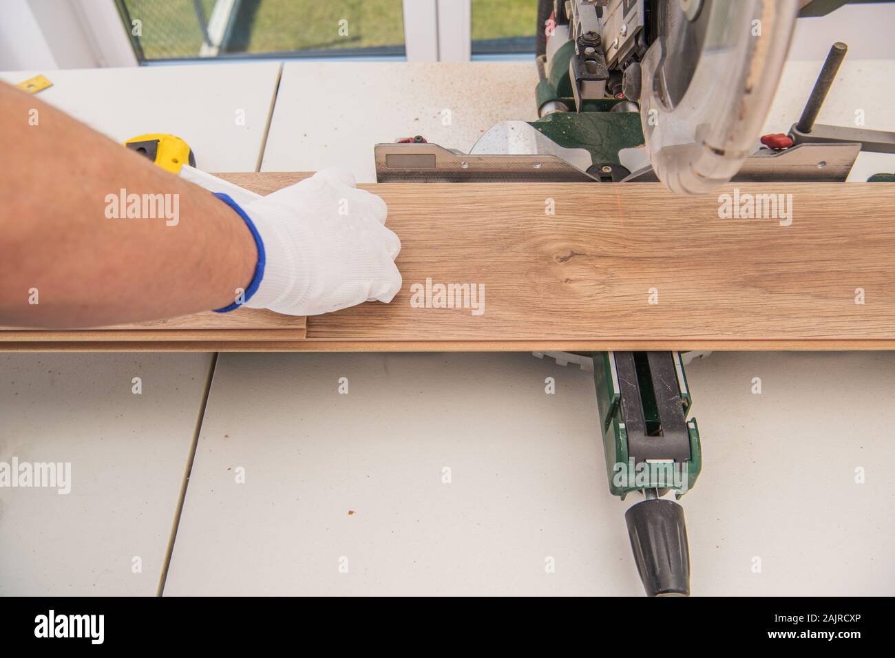 Home Improvement Contractor Replacing Wooden Floor and Cutting Wood