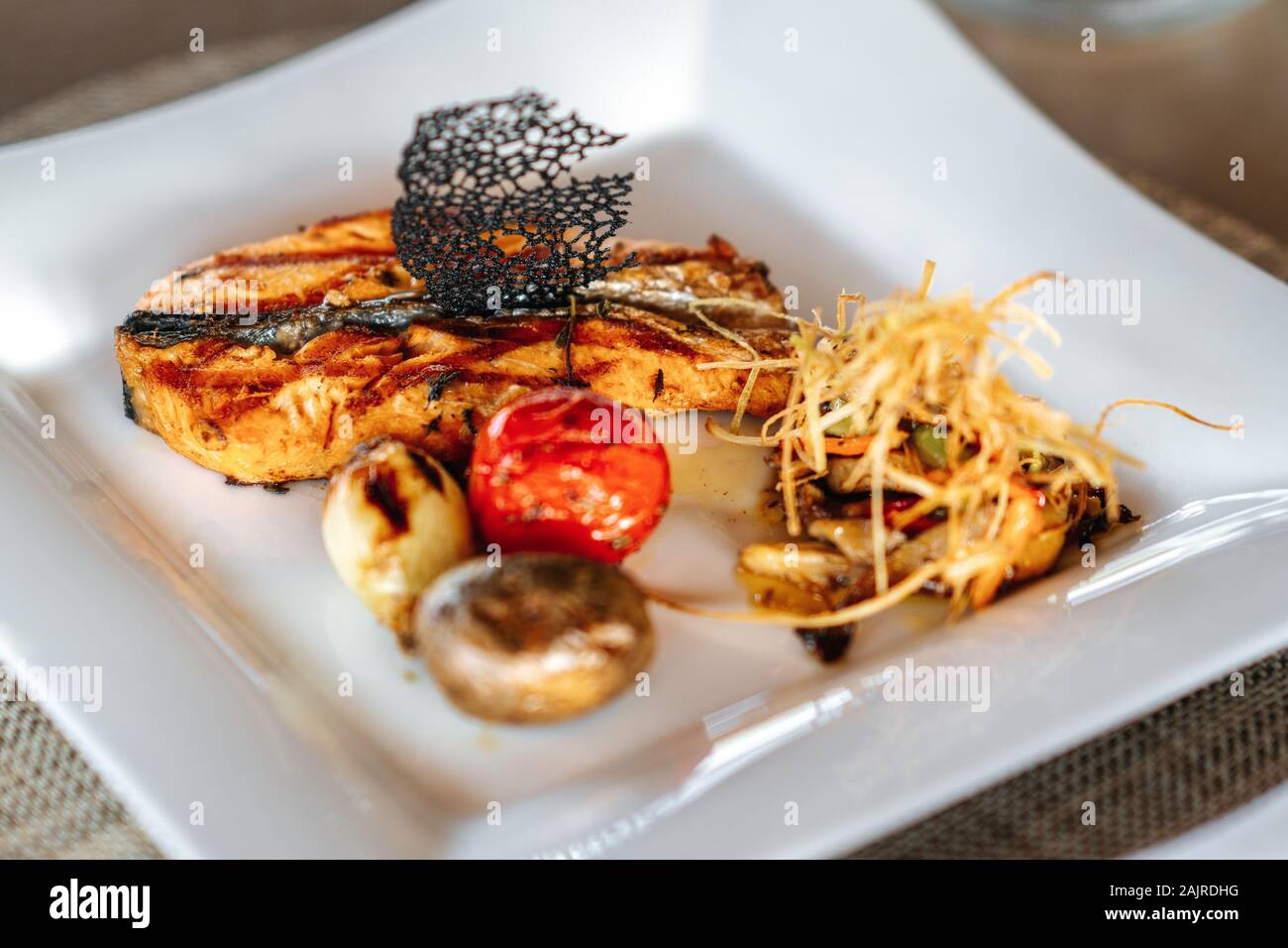 A delicious roasted salmon is served in a elegance restaurant or hotel. Stock Photo