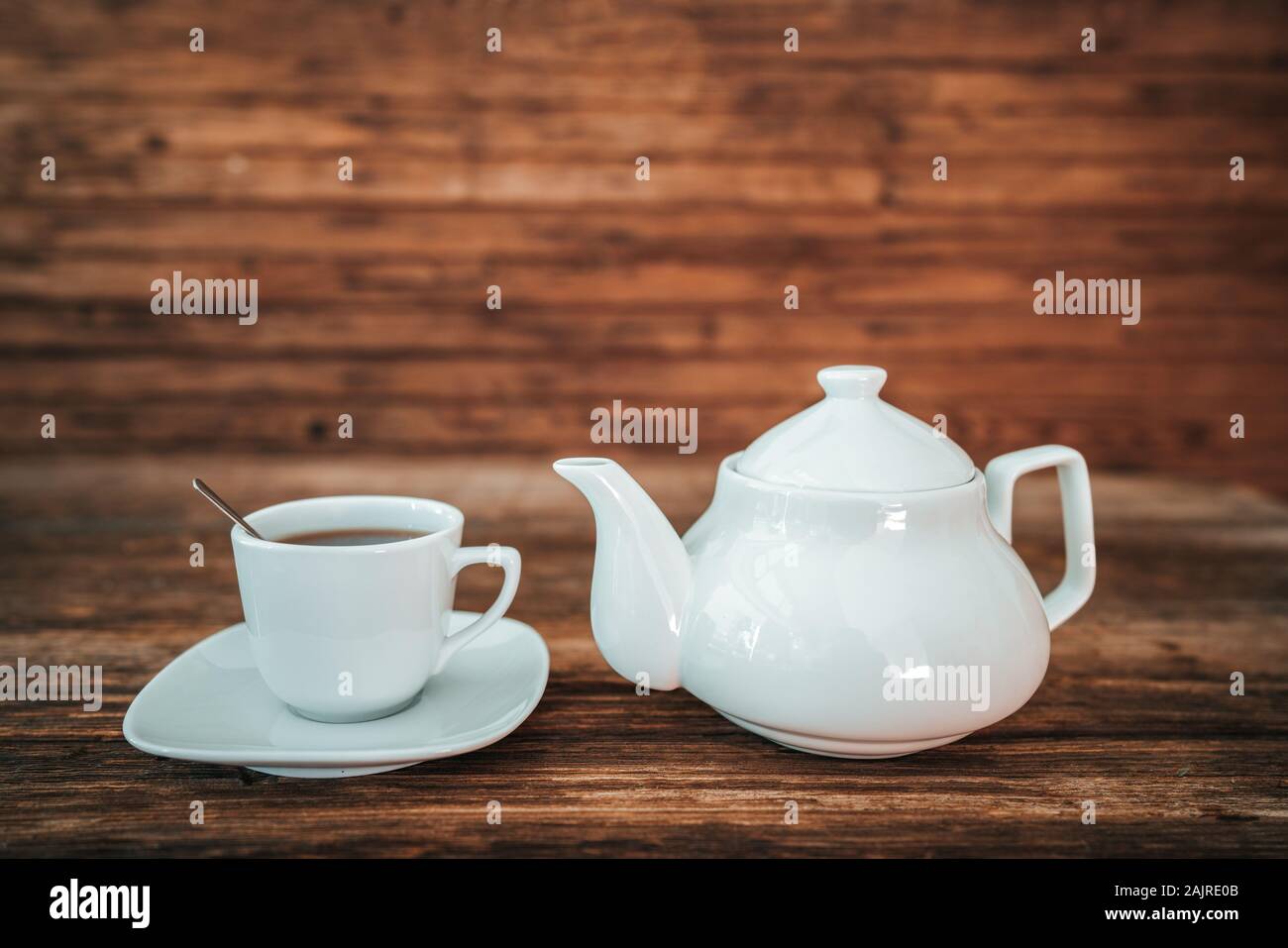 Tea time, brewing tea, cup of freshly brewed tea, warm soft and light, with wooden background. Stock Photo