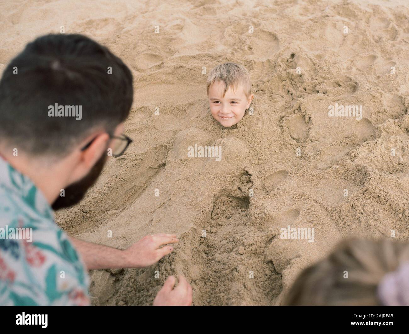 A young family enjoying a fun day on the beach during their vacation. Stock Photo