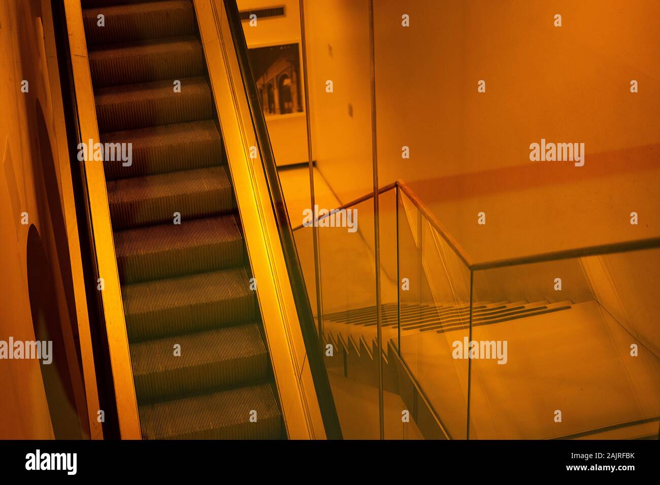 Mechanical stairs next to normal stairs on a yellow background. Architectural concept. Stock Photo