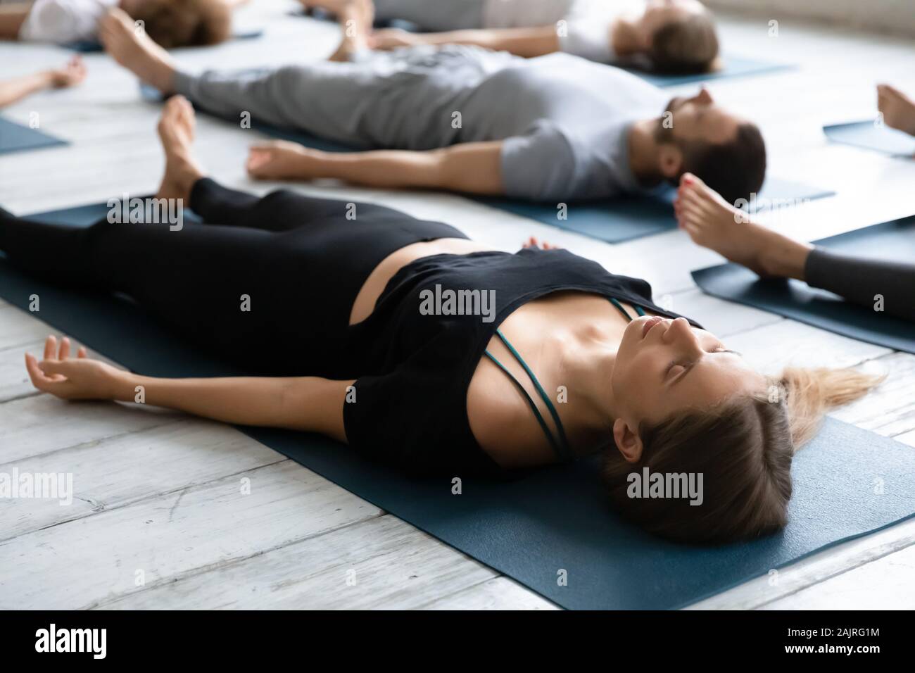 Beautiful woman meditating in Savasana pose close up, practicing yoga Stock Photo