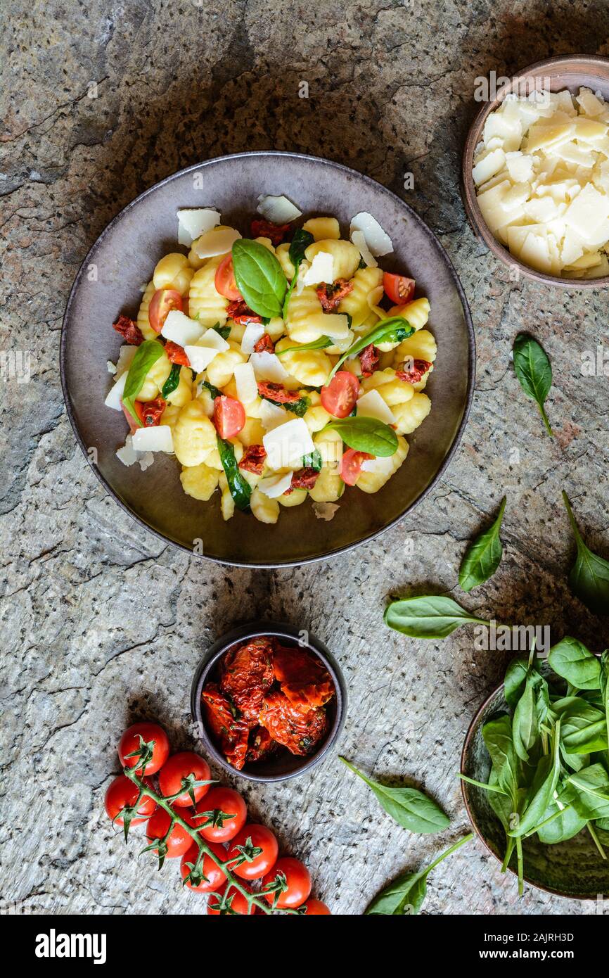 Low calorie gnocchi pasta salad with fresh and steamed spinach, sun