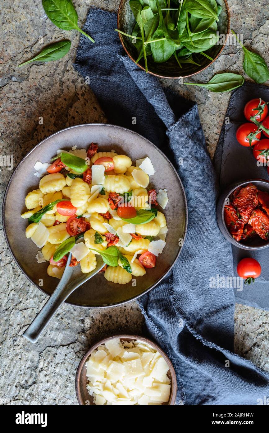 Low calorie gnocchi pasta salad with fresh and steamed spinach, sun