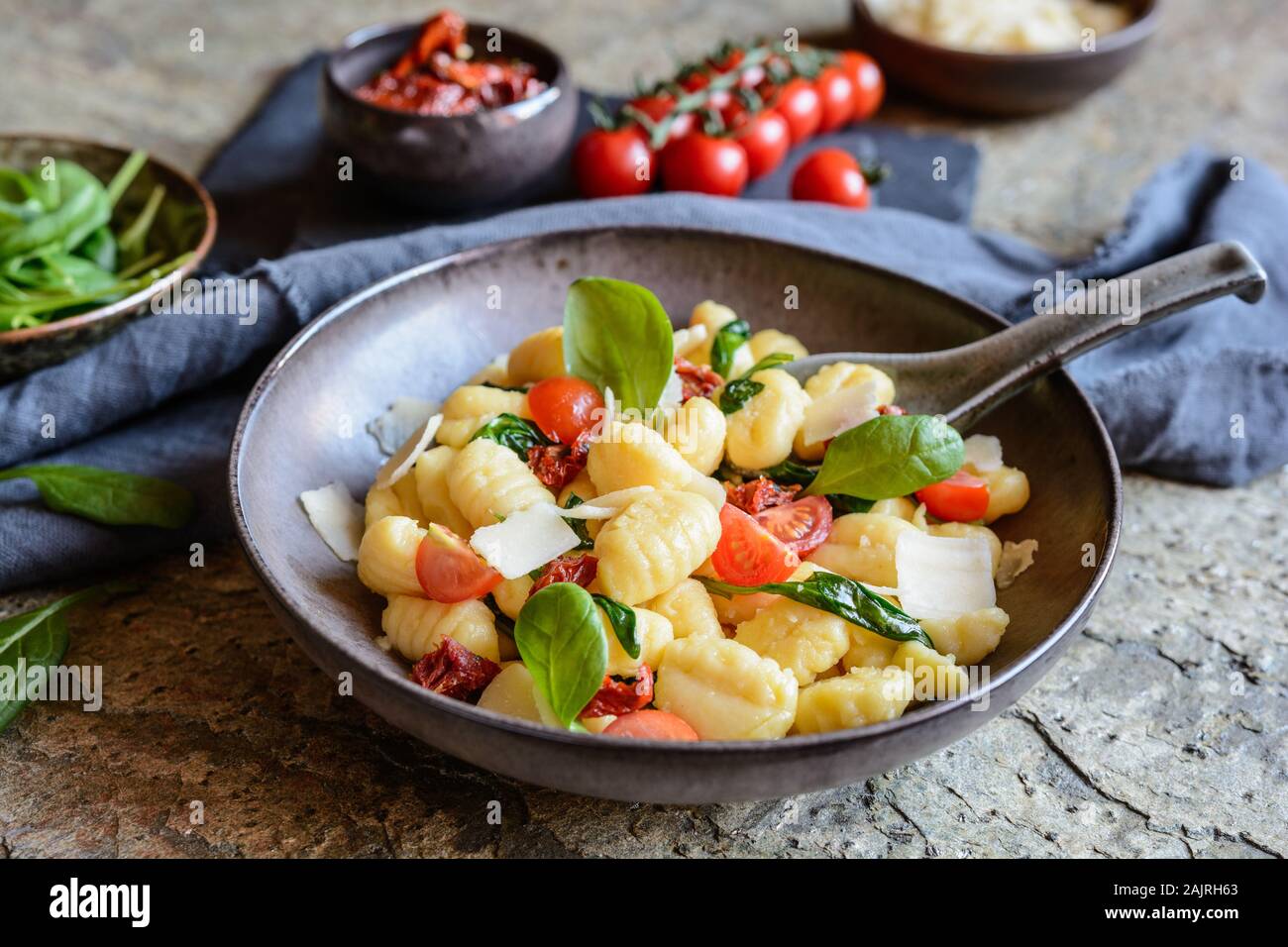 Low calorie gnocchi pasta salad with fresh and steamed spinach, sun