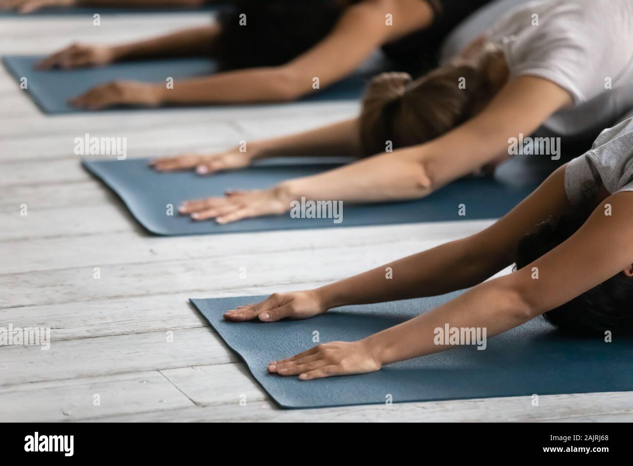 Diverse people practicing yoga close up, doing Child exercise Stock Photo